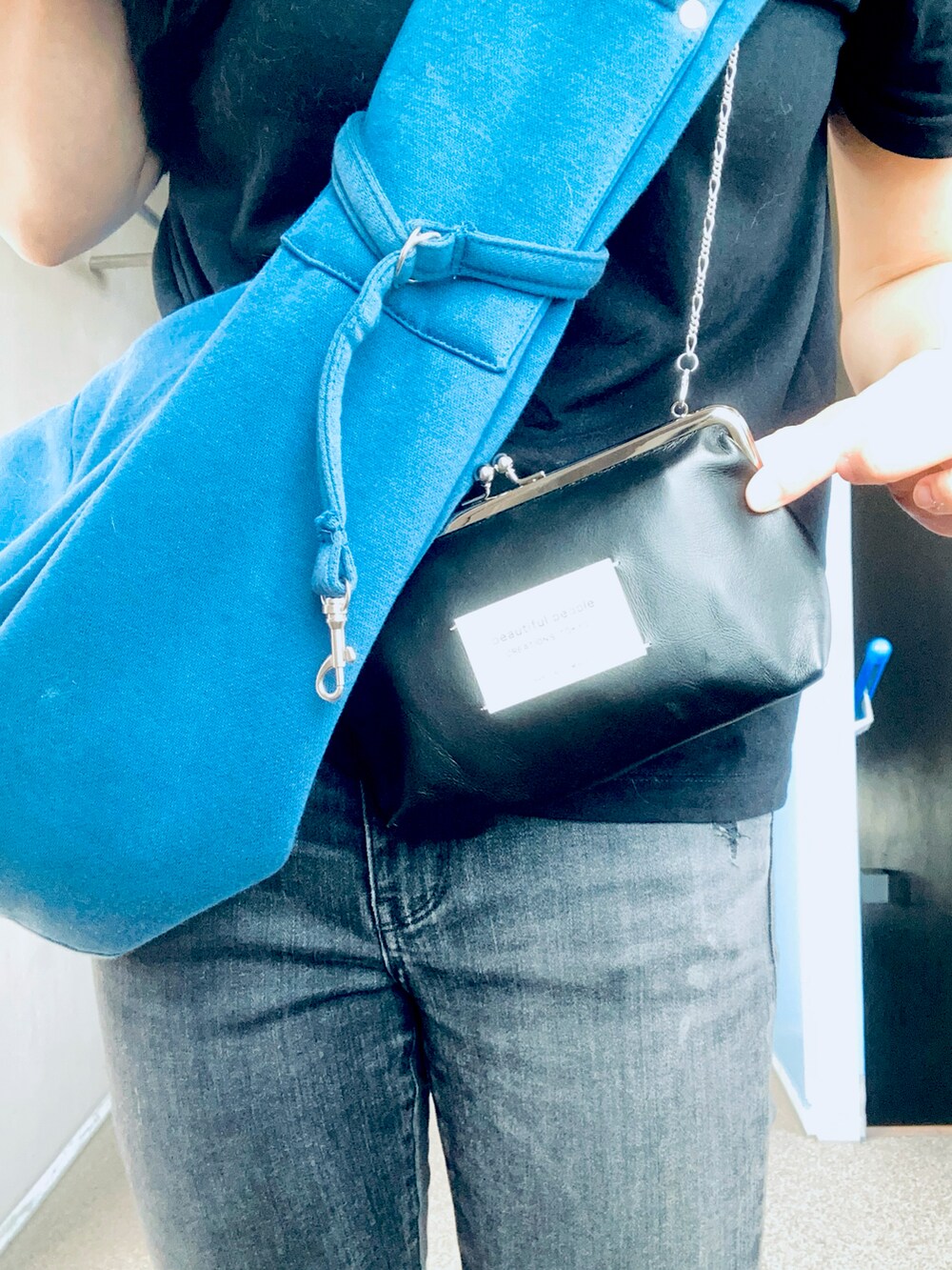 ブラック系のデニムパンツ、ブラック系のショルダーバッグ、ブルー系のその他ペットグッズを着用したレディースの夏コーディネートの3枚目の写真