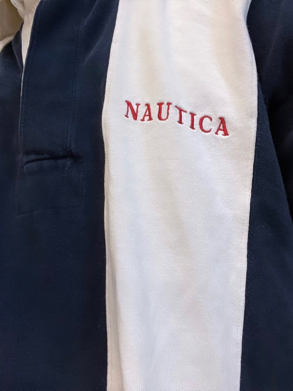 ブラック系のスニーカー、ブルー系のデニムパンツ、ホワイト系のポロシャツを着用したメンズの冬コーディネートの2枚目の写真