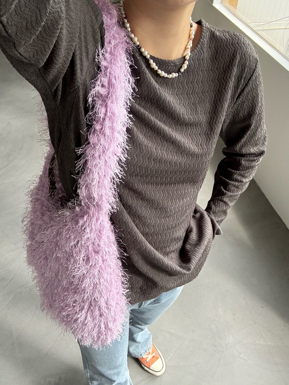 グレー系のカーディガン/ボレロ、パープル系のトートバッグ、ブルー系のデニムパンツを着用したレディースの秋コーディネートの3枚目の写真