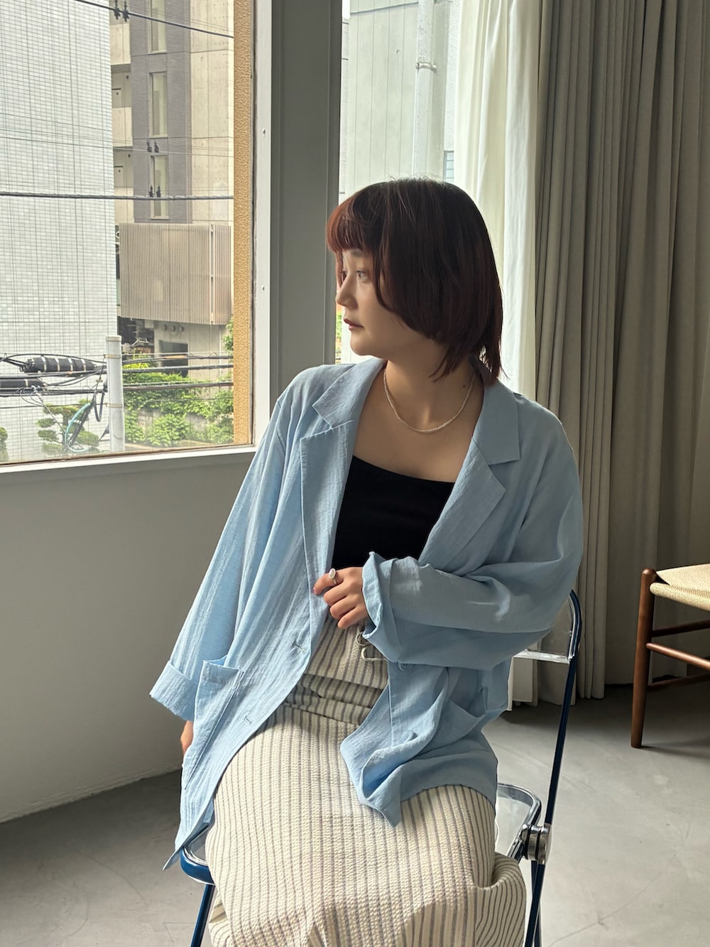 ブルー系のテーラードジャケット、ホワイト系のスカートを着用したレディースの夏コーディネートの2枚目の写真