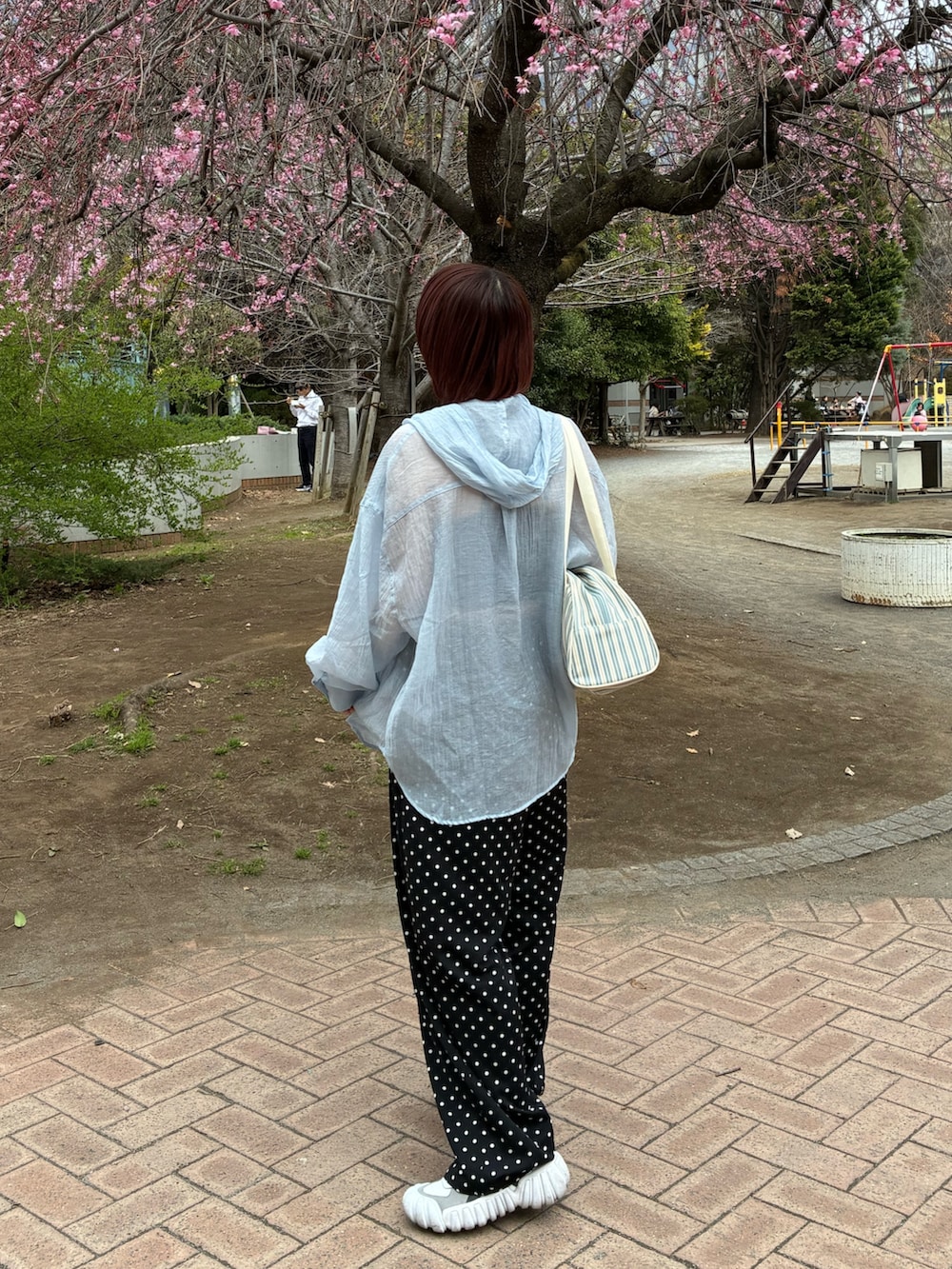 ブルー系のトップス、ホワイト系のボストンバッグ、ホワイト系のスニーカーを着用したレディースの春コーディネートの5枚目の写真