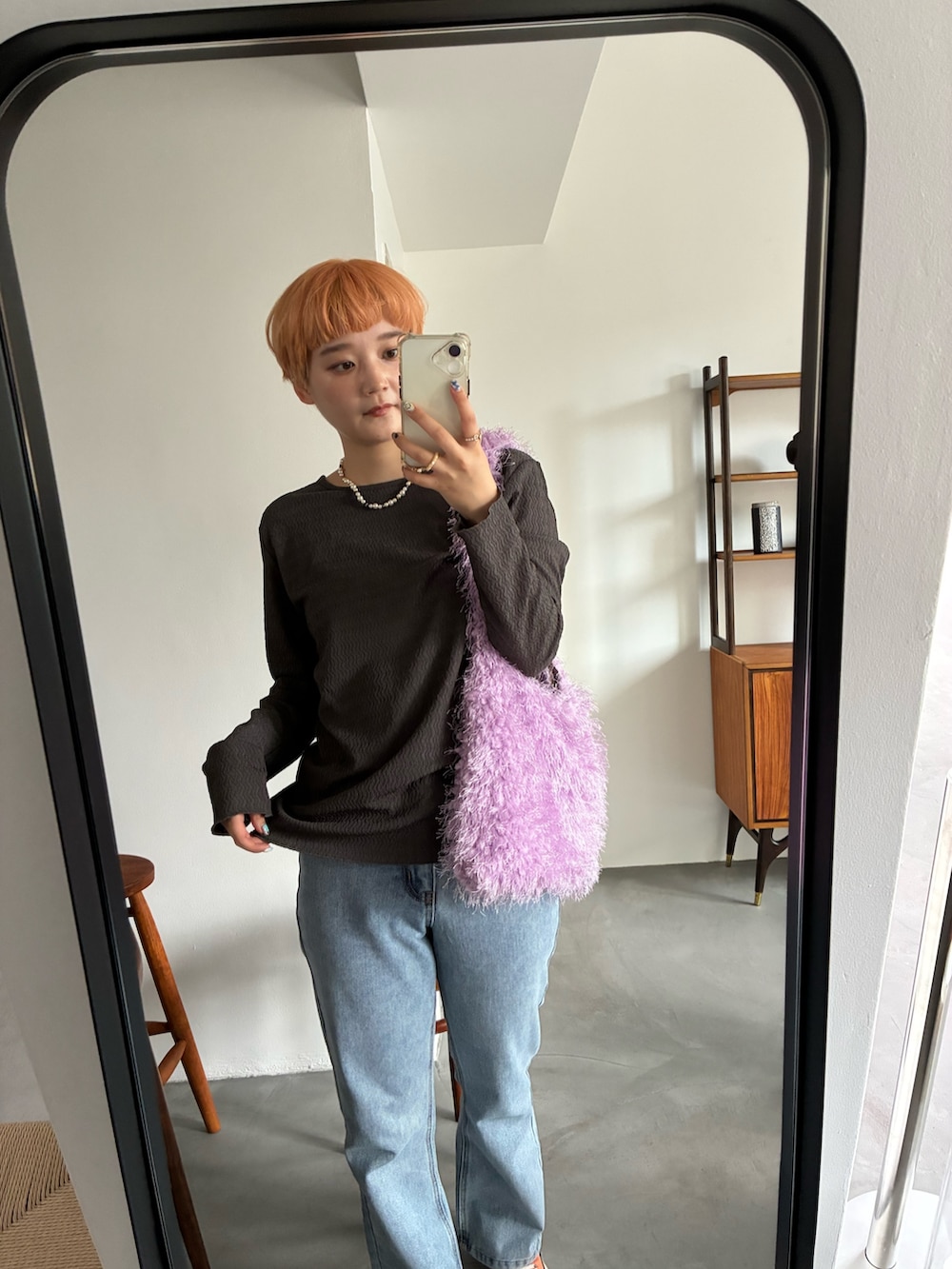 グレー系のカーディガン/ボレロ、パープル系のトートバッグ、ブルー系のデニムパンツを着用したレディースの秋コーディネートの2枚目の写真