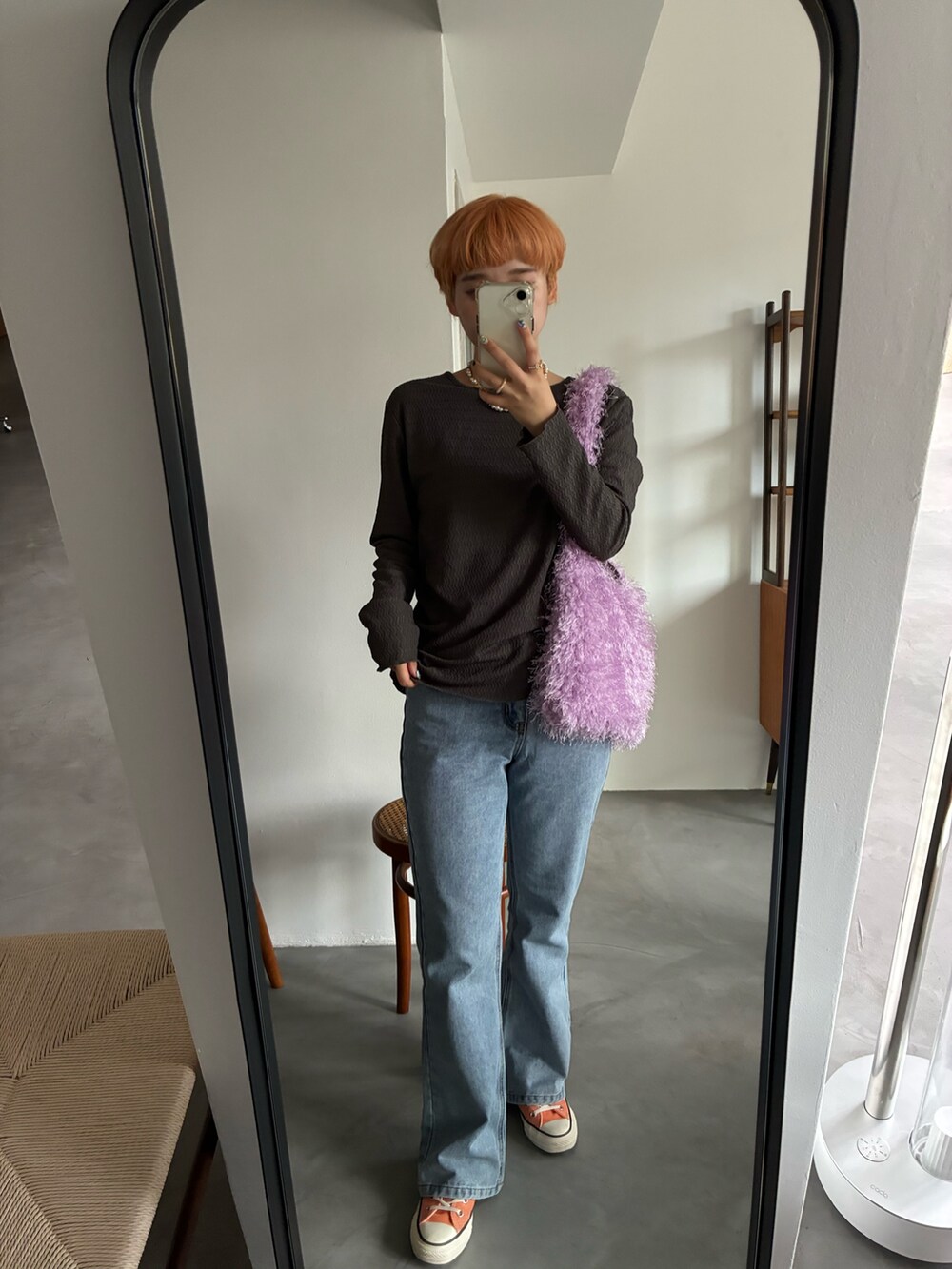 グレー系のカーディガン/ボレロ、パープル系のトートバッグ、ブルー系のデニムパンツを着用したレディースの秋コーディネートの4枚目の写真