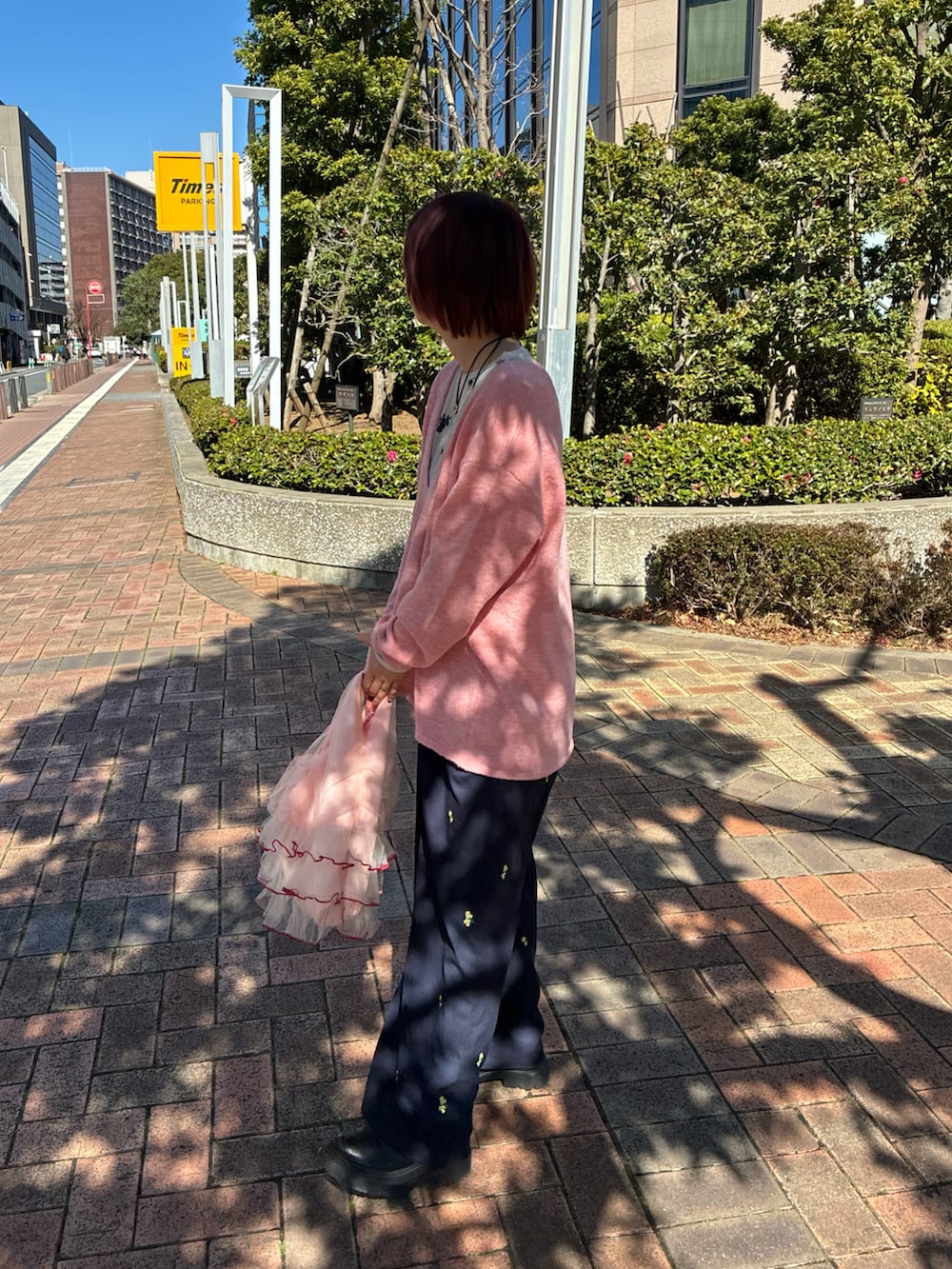 ピンク系のニット/セーター、ブルー系のパンツ、ホワイト系のトップスを着用したレディースの冬コーディネートの2枚目の写真