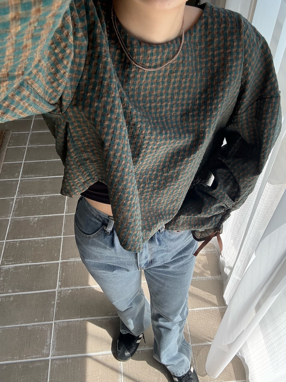 グリーン系のシャツ/ブラウス、ブルー系のデニムパンツを着用したレディースの春コーディネートの4枚目の写真