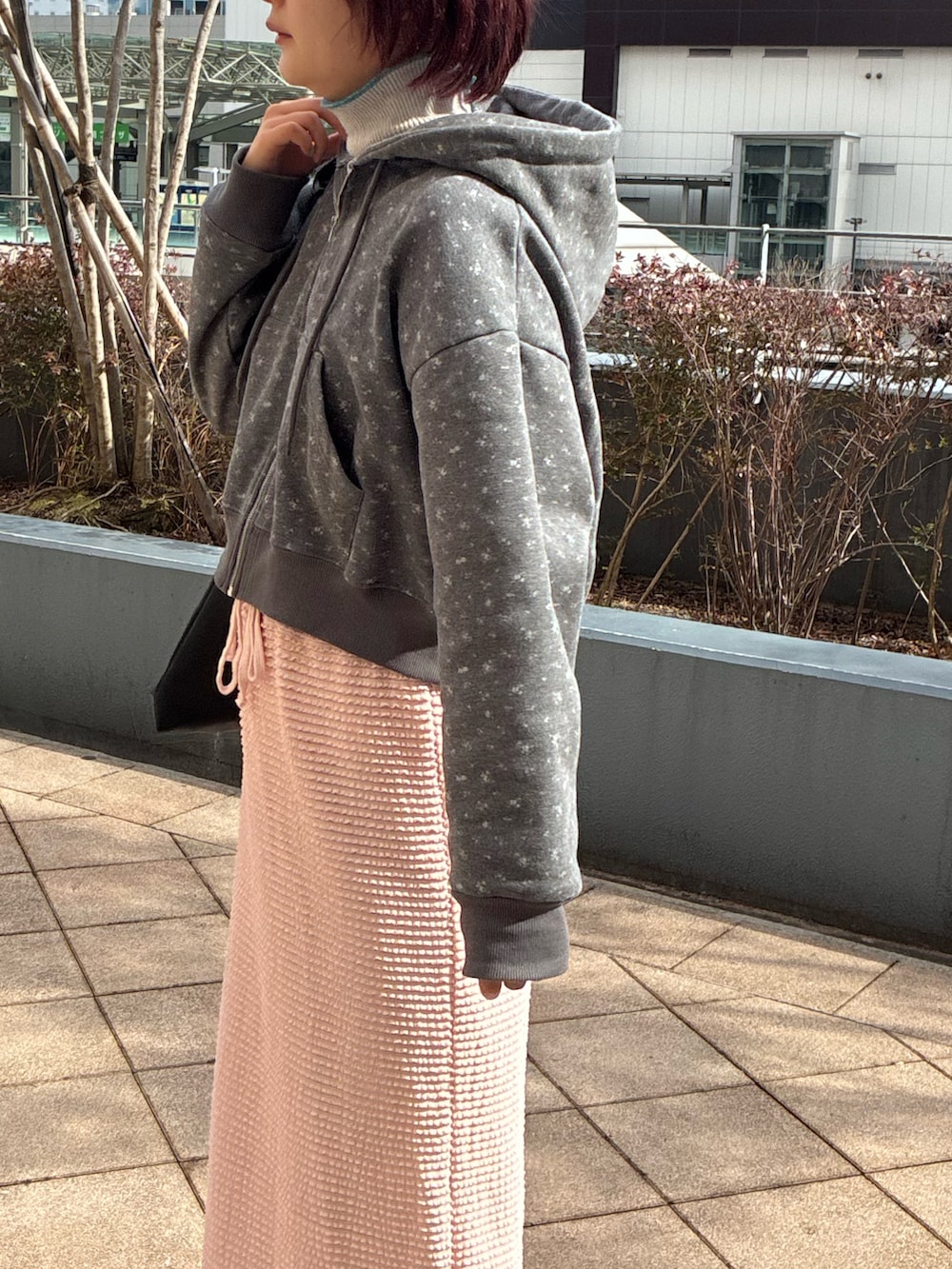 ピンク系のスカート、グレー系のパーカー、グレー系のニット/セーターを着用したレディースの冬コーディネートの4枚目の写真