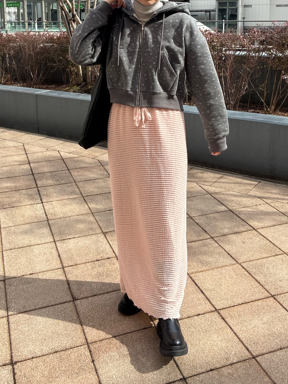 ピンク系のスカート、グレー系のパーカー、グレー系のニット/セーターを着用したレディースの冬コーディネートの3枚目の写真