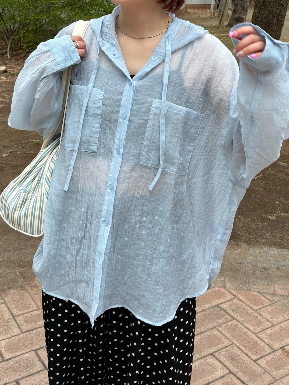 ブルー系のトップス、ホワイト系のボストンバッグ、ホワイト系のスニーカーを着用したレディースの春コーディネートの3枚目の写真