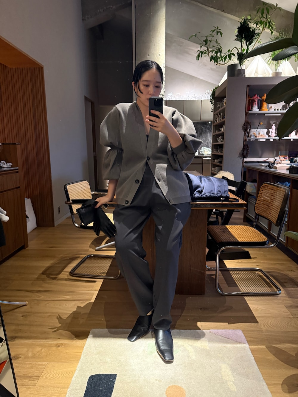 グレー系のスラックス、ベージュ系のカーディガン/ボレロを着用したレディースの秋コーディネートの2枚目の写真