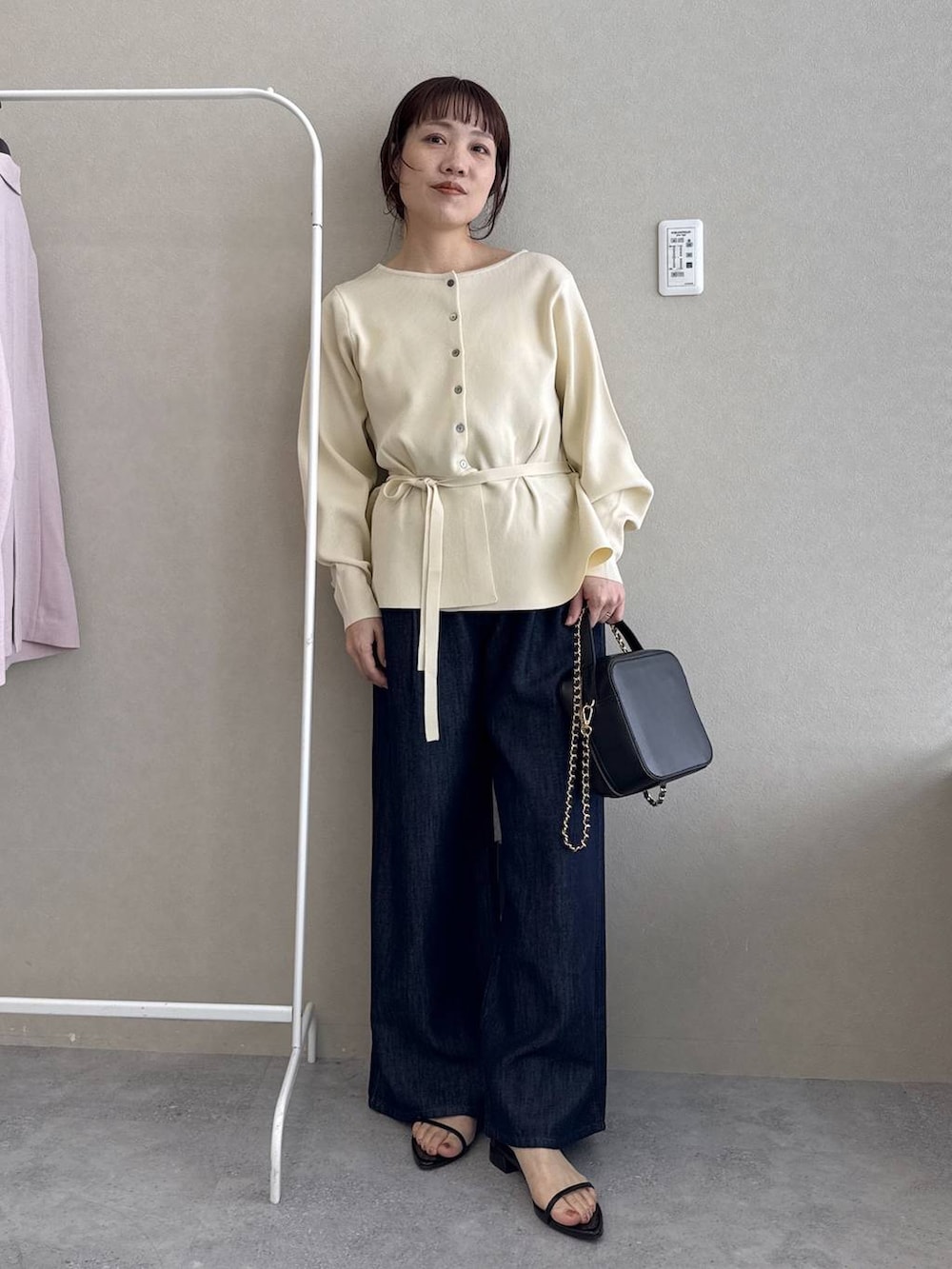 ホワイト系のカーディガン/ボレロ、ブラック系のショルダーバッグ、ブラック系のサンダルを着用したレディースの春コーディネートの3枚目の写真