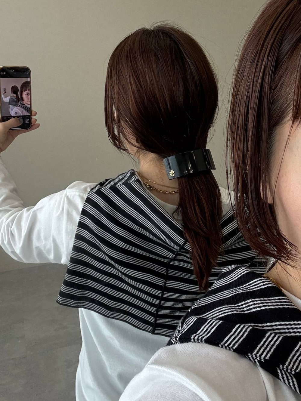 ブラック系のスカート、ホワイト系のTシャツ/カットソー、ブラック系のバレッタ/ヘアクリップを着用したレディースの秋コーディネートの7枚目の写真