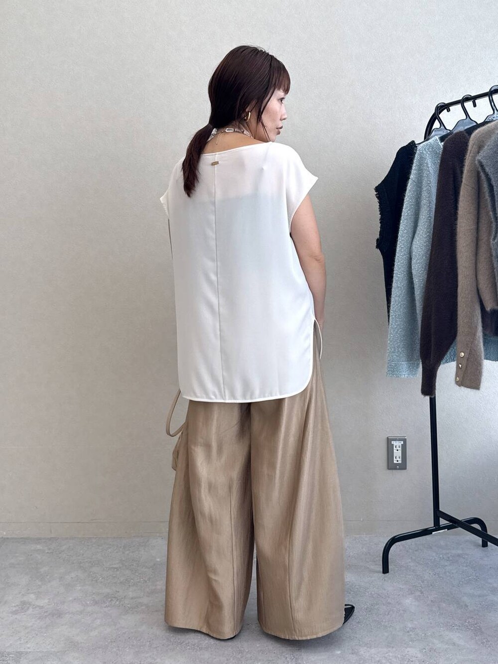 ブラック系のサンダル、ベージュ系のその他パンツ、ホワイト系のTシャツ/カットソーを着用したレディースの夏コーディネートの3枚目の写真