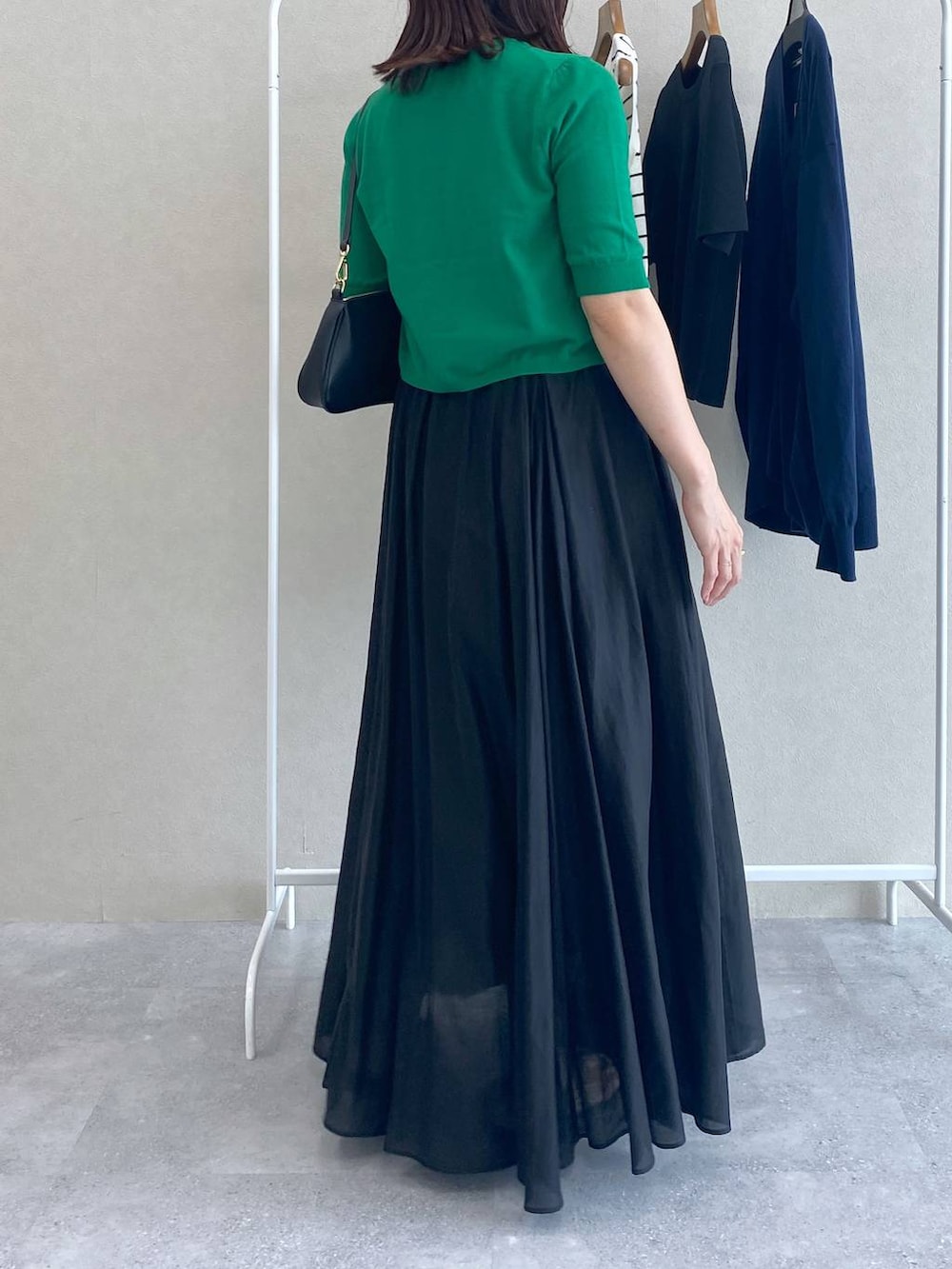 グリーン系のカーディガン/ボレロ、ブラック系のショルダーバッグ、ブラック系のスカートを着用したレディースの夏コーディネートの3枚目の写真