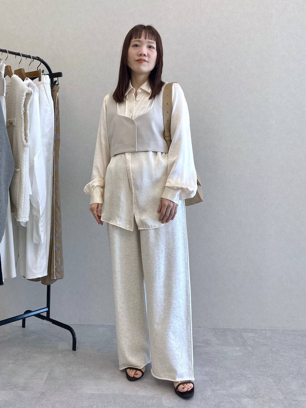 ホワイト系のシャツ/ブラウス、ブラウン系のショルダーバッグ、グレー系のスウェットパンツを着用したレディースの冬コーディネートの2枚目の写真