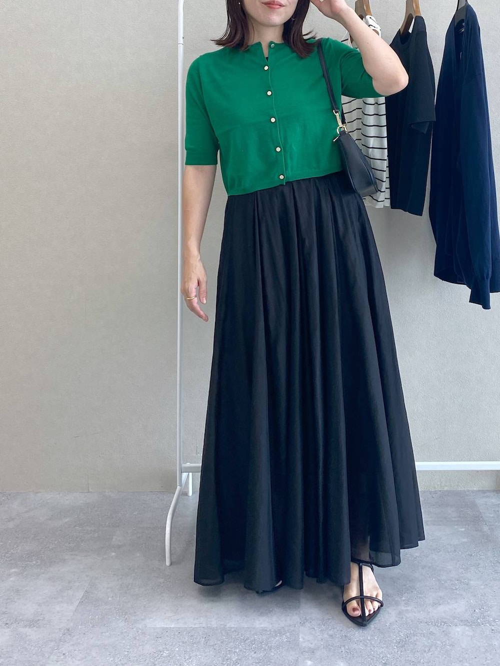 グリーン系のカーディガン/ボレロ、ブラック系のショルダーバッグ、ブラック系のスカートを着用したレディースの夏コーディネートの4枚目の写真