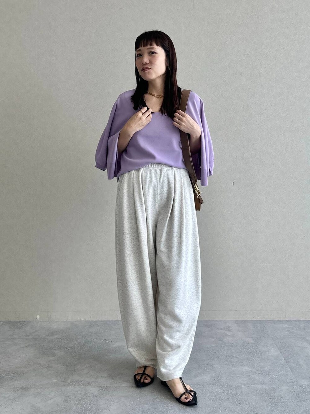 ブラック系のサンダル、グレー系のスウェットパンツ、パープル系のタンクトップを着用したレディースの夏コーディネートの6枚目の写真