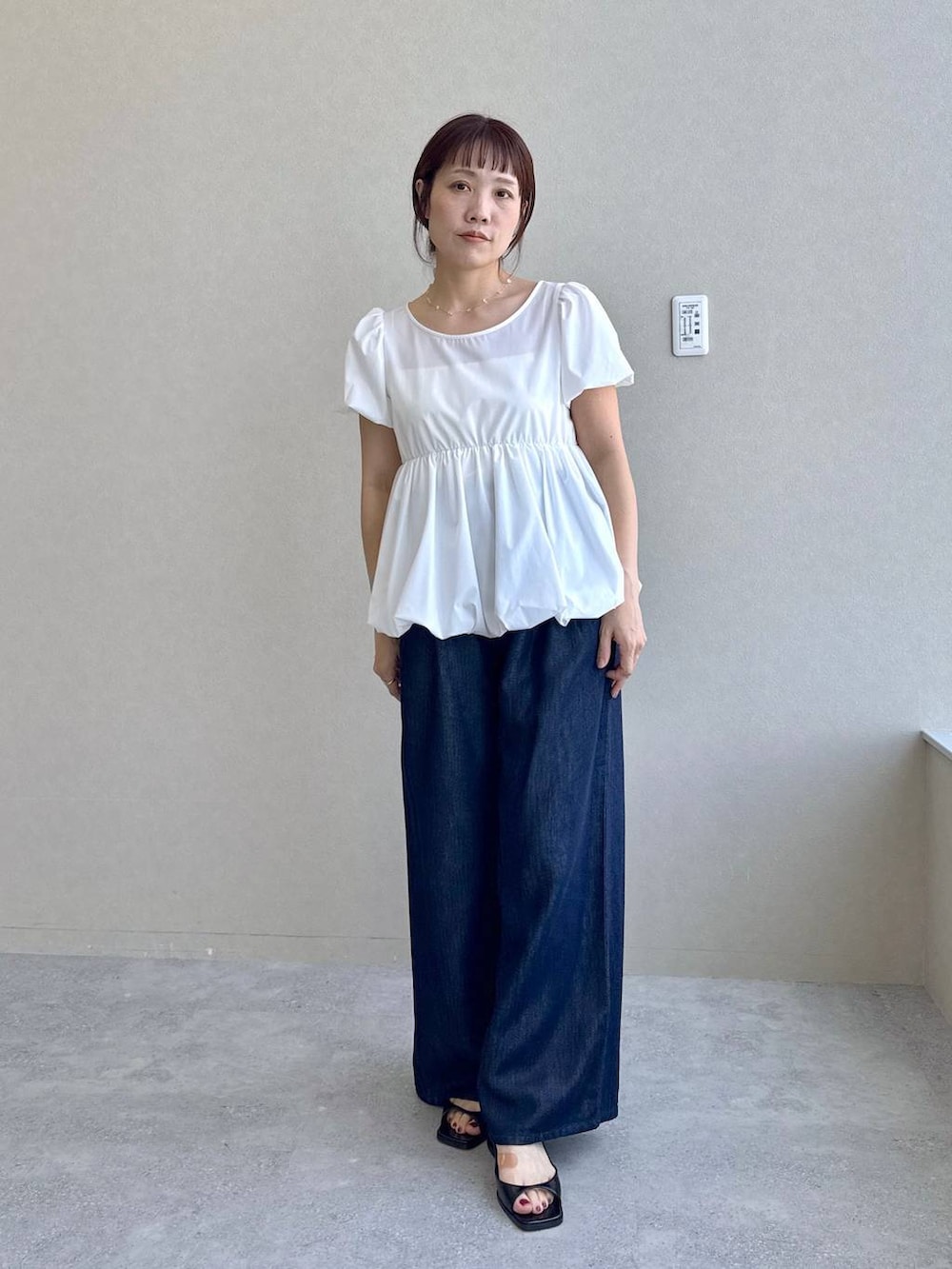 ブルー系のデニムパンツ、ブラック系のパンプス、ホワイト系のシャツ/ブラウスを着用したレディースの春コーディネートの3枚目の写真