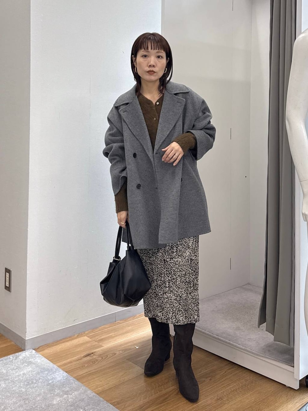 グレー系のその他アウター、ベージュ系のスカート、ブラウン系のブーツを着用したレディースの秋コーディネートの4枚目の写真