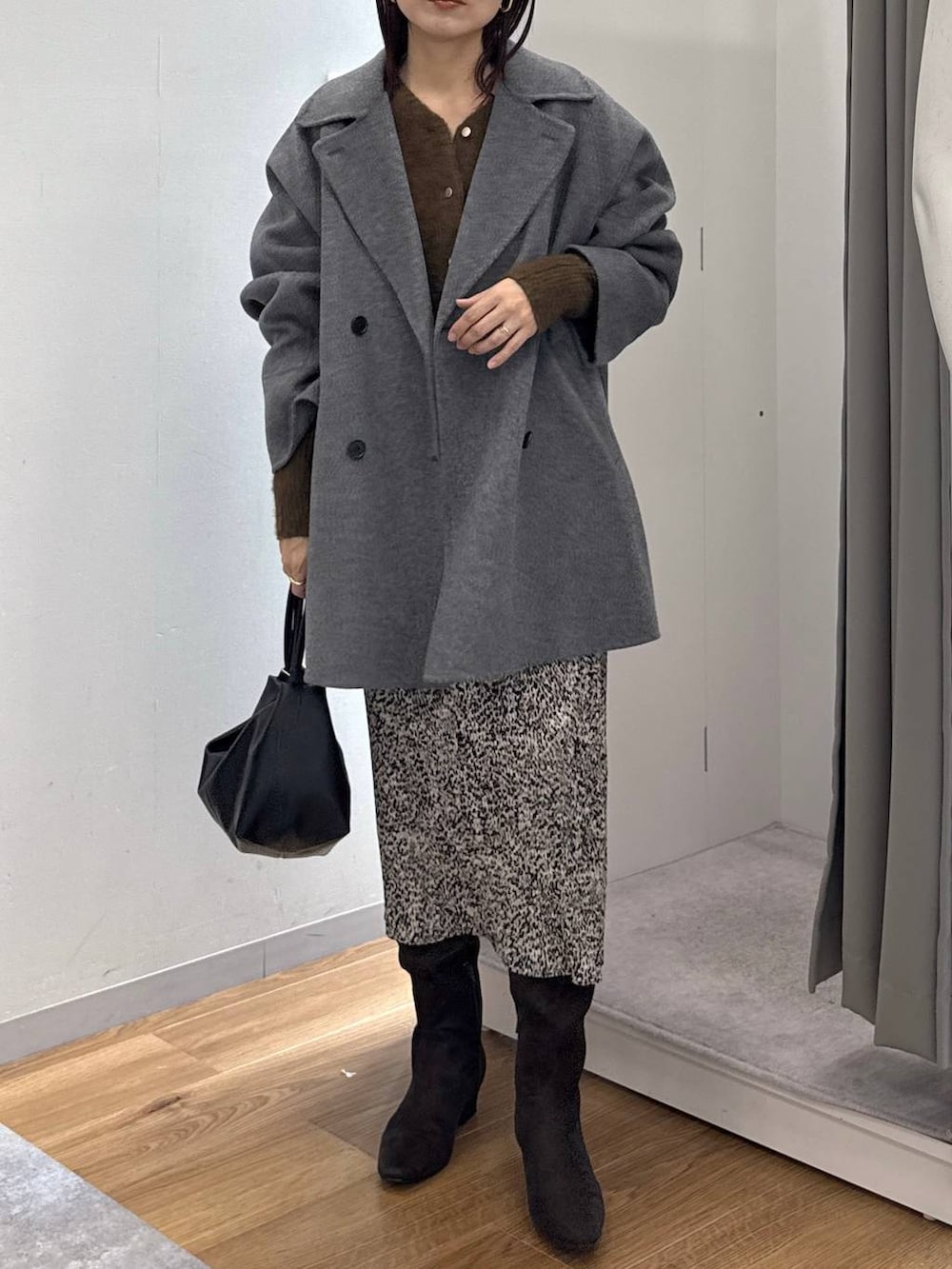 グレー系のその他アウター、ベージュ系のスカート、ブラウン系のブーツを着用したレディースの秋コーディネートの8枚目の写真