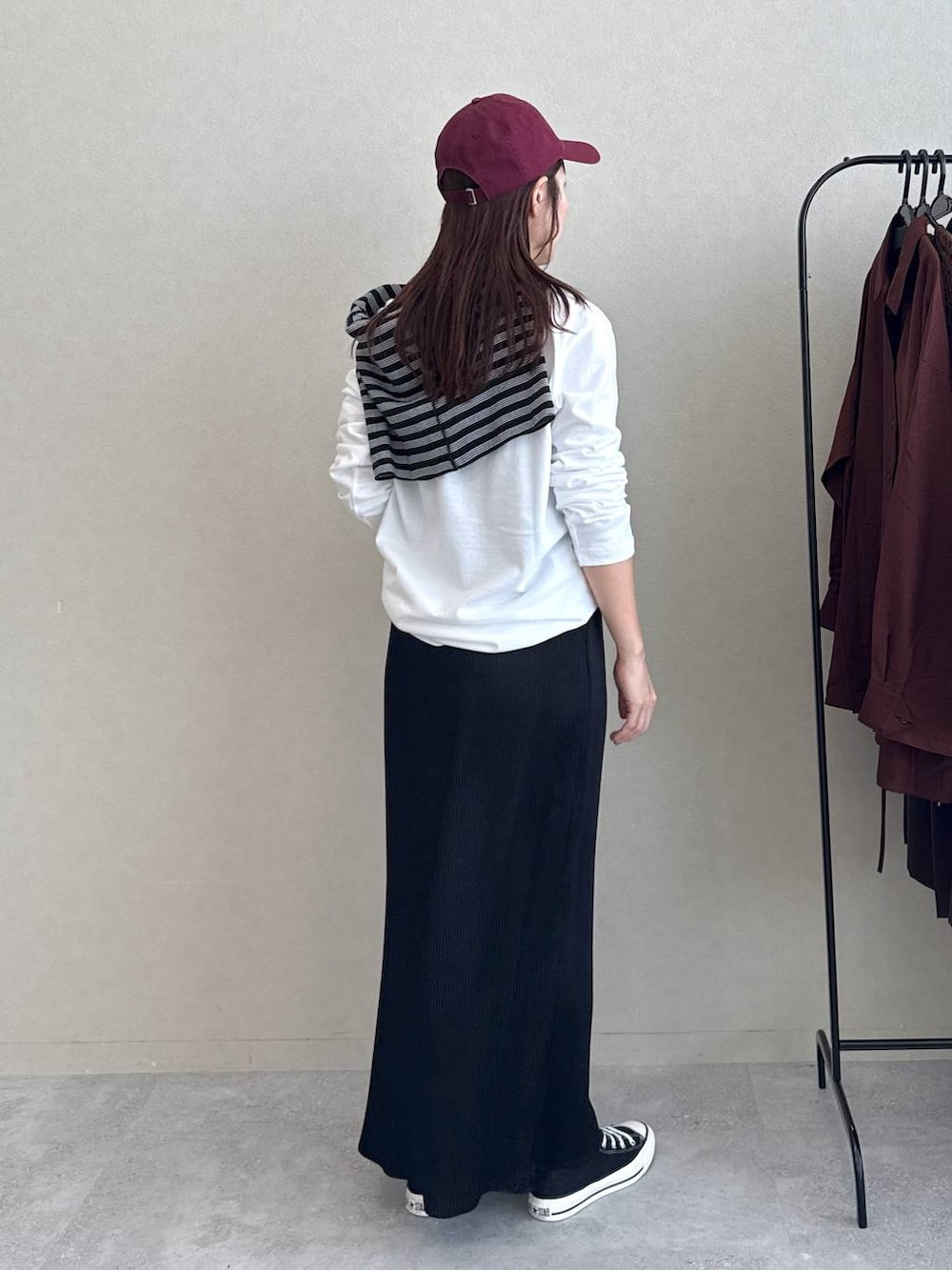 ブラック系のスカート、ホワイト系のTシャツ/カットソー、ブラック系のバレッタ/ヘアクリップを着用したレディースの秋コーディネートの2枚目の写真