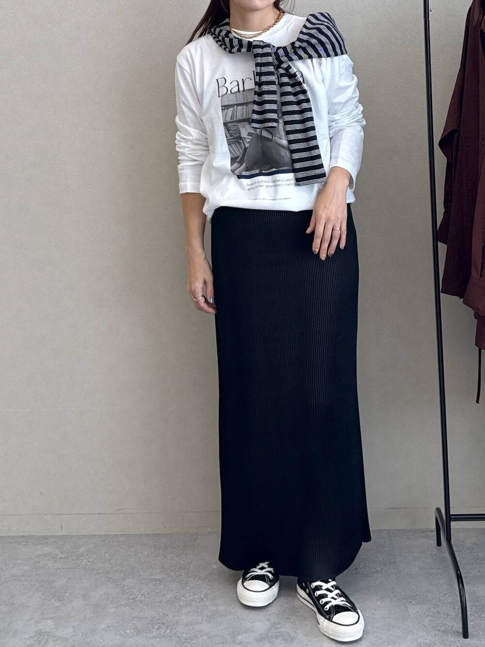 ブラック系のスカート、ホワイト系のTシャツ/カットソー、ブラック系のバレッタ/ヘアクリップを着用したレディースの秋コーディネートの4枚目の写真