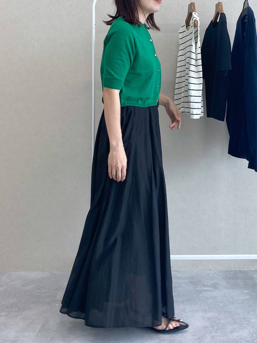 グリーン系のカーディガン/ボレロ、ブラック系のショルダーバッグ、ブラック系のスカートを着用したレディースの夏コーディネートの2枚目の写真