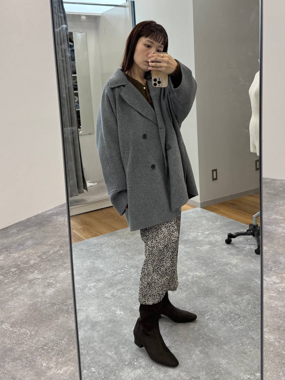 グレー系のその他アウター、ベージュ系のスカート、ブラウン系のブーツを着用したレディースの秋コーディネートの2枚目の写真