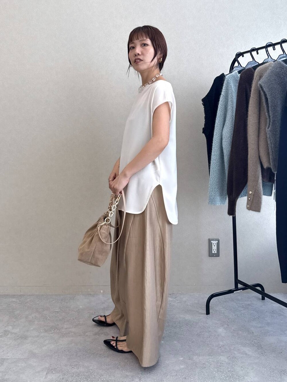 ブラック系のサンダル、ベージュ系のその他パンツ、ホワイト系のTシャツ/カットソーを着用したレディースの夏コーディネートの4枚目の写真
