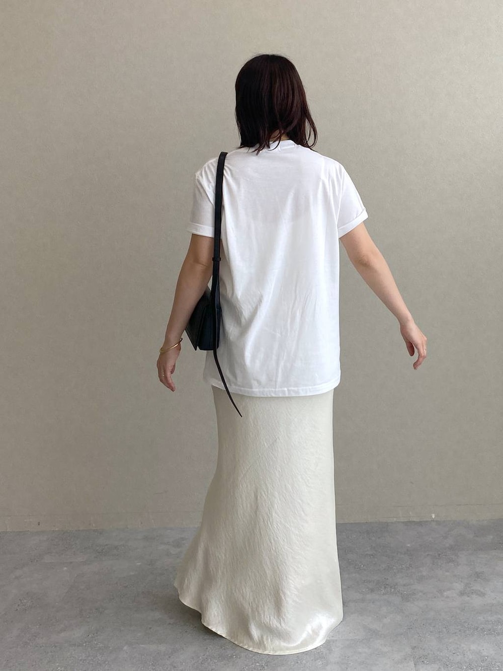 ホワイト系のTシャツ/カットソー、ホワイト系のスカート、ブラック系のサンダルを着用したレディースの春コーディネートの3枚目の写真