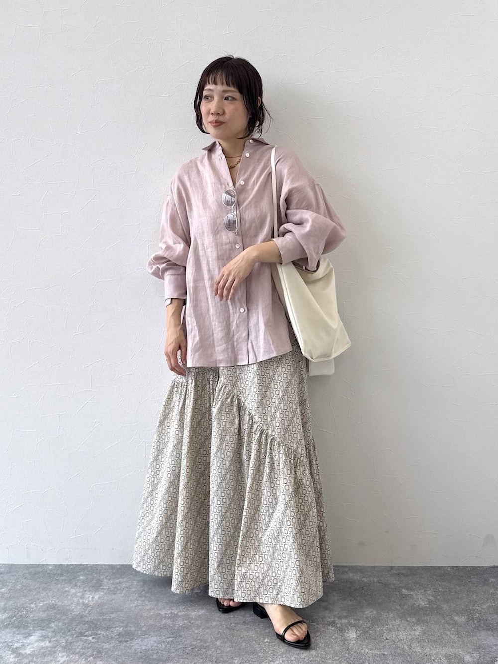 ピンク系のシャツ/ブラウス、ホワイト系のショルダーバッグ、ブラック系のサンダルを着用したレディースの春コーディネートの2枚目の写真