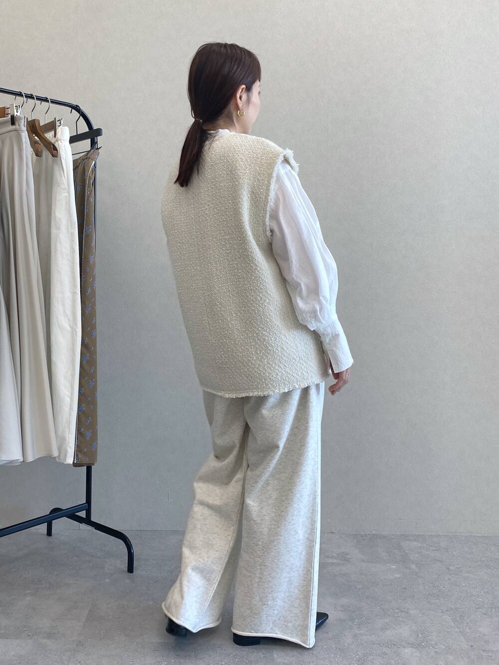 ホワイト系のシャツ/ブラウス、グレー系のスウェットパンツ、ホワイト系のベストを着用したレディースの冬コーディネートの2枚目の写真