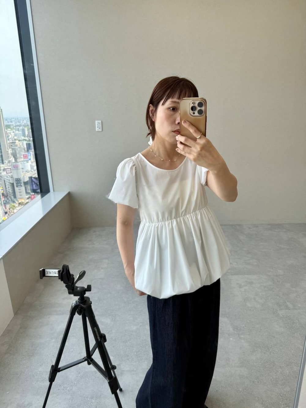ブルー系のデニムパンツ、ブラック系のパンプス、ホワイト系のシャツ/ブラウスを着用したレディースの春コーディネートの2枚目の写真
