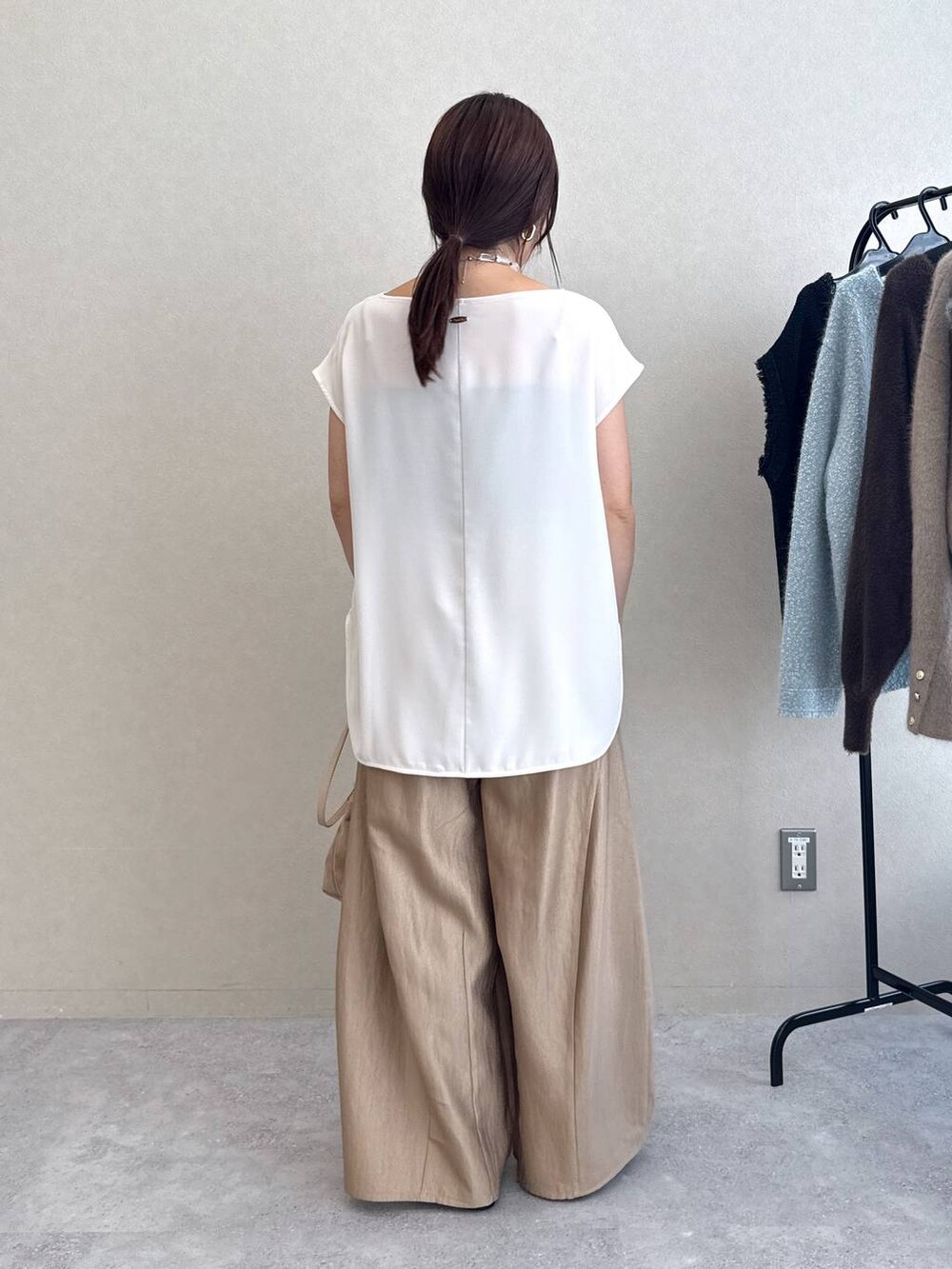 ブラック系のサンダル、ベージュ系のその他パンツ、ホワイト系のTシャツ/カットソーを着用したレディースの夏コーディネートの2枚目の写真