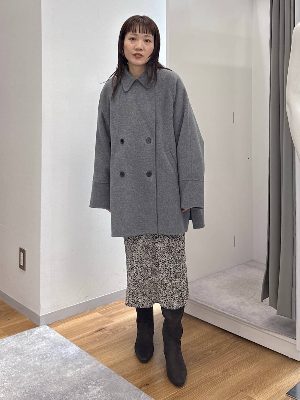 グレー系のその他アウター、ベージュ系のスカート、ブラウン系のブーツを着用したレディースの秋コーディネートの7枚目の写真