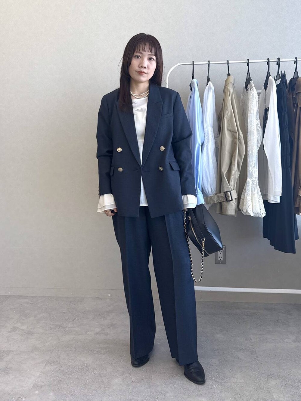 ホワイト系のシャツ/ブラウス、ブルー系のスラックス、ブルー系のテーラードジャケットを着用したレディースの冬コーディネートの6枚目の写真