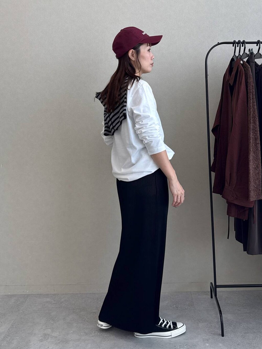 ブラック系のスカート、ホワイト系のTシャツ/カットソー、ブラック系のバレッタ/ヘアクリップを着用したレディースの秋コーディネートの3枚目の写真