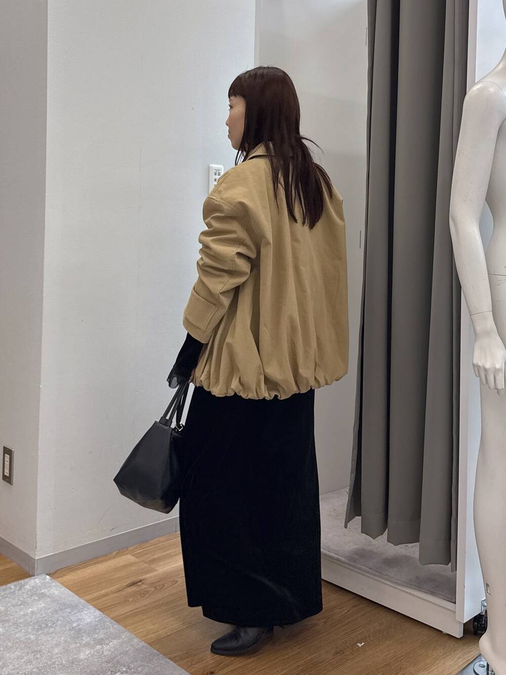 ブラック系のブーツ、レッド系のショルダーバッグ、ブラック系のショルダーバッグを着用したレディースの冬コーディネートの2枚目の写真