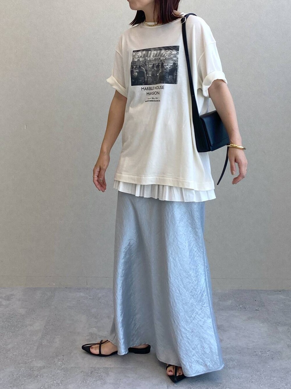 ブルー系のスカート、ホワイト系のTシャツ/カットソー、ブラック系のサンダルを着用したレディースの夏コーディネートの2枚目の写真