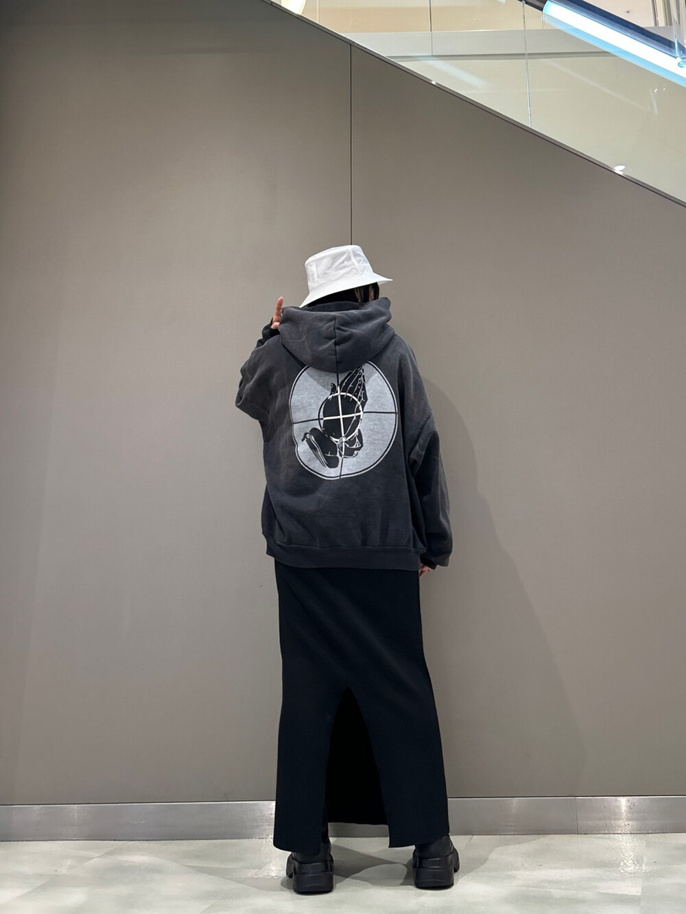 ブラック系のパーカー、ホワイト系のハットを着用したレディースの春コーディネートの2枚目の写真