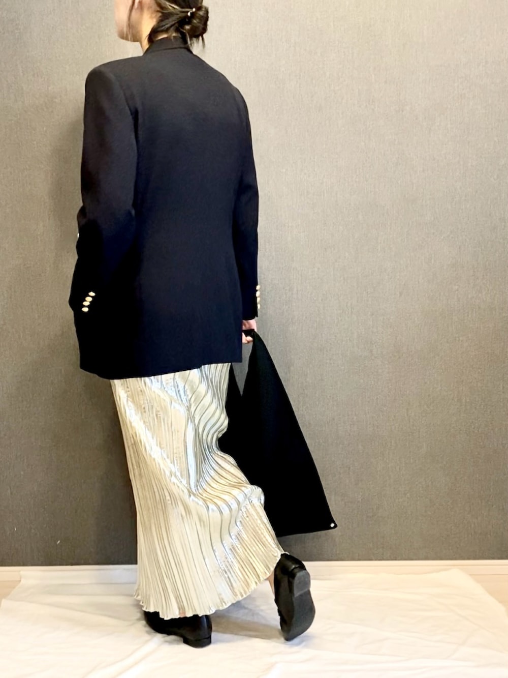 ブラック系のニット/セーター、ブラック系のハンドバッグ、ブラック系のローファーを着用したレディースの春コーディネートの2枚目の写真