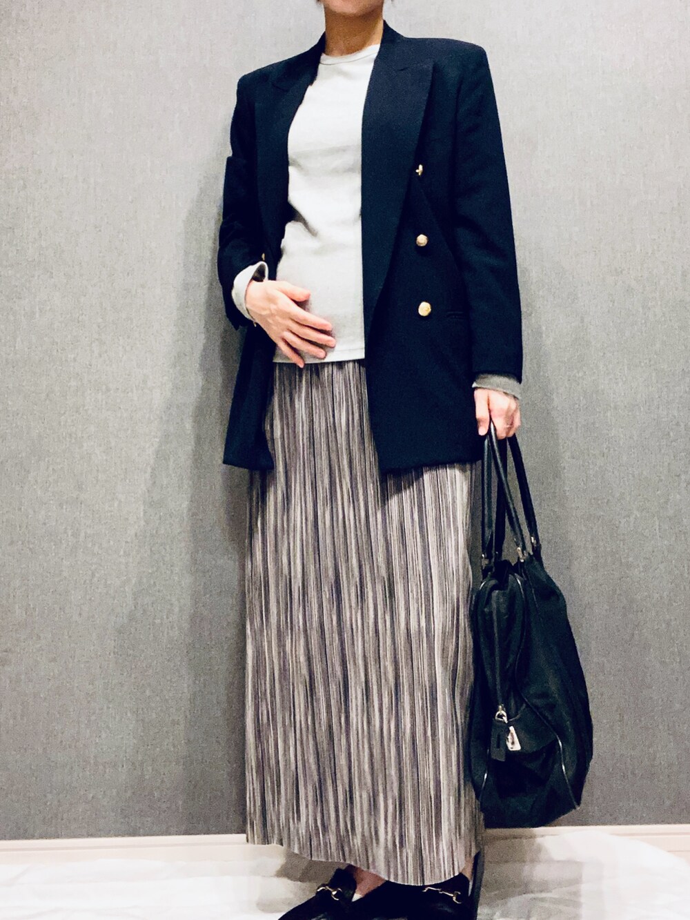 ブラック系のトートバッグ、ブラック系のテーラードジャケット、グレー系のTシャツ/カットソーを着用したレディースの春コーディネートの2枚目の写真