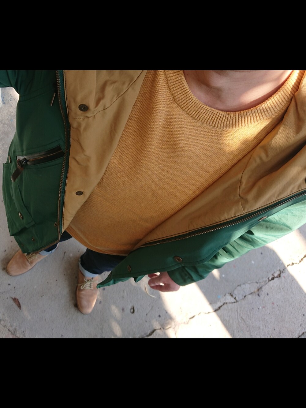 ブルー系のデニムパンツ、ベージュ系のシューズ、グリーン系のマウンテンパーカーを着用したメンズの秋コーディネートの3枚目の写真