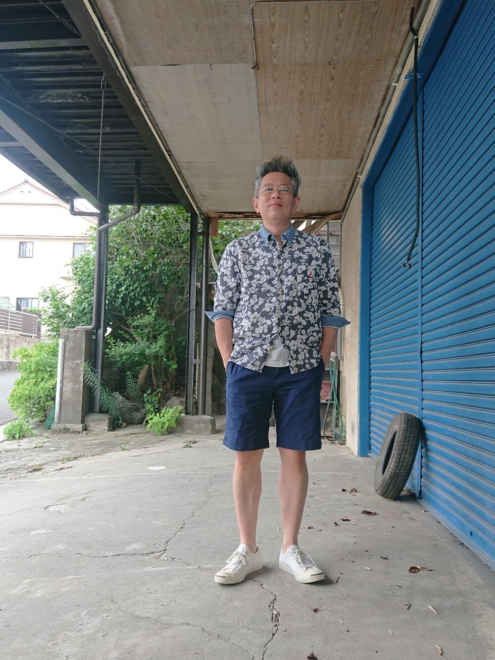 ホワイト系のスニーカー、ブルー系のチノパンツ、ブルー系のシャツ/ブラウスを着用したメンズの夏コーディネートの3枚目の写真