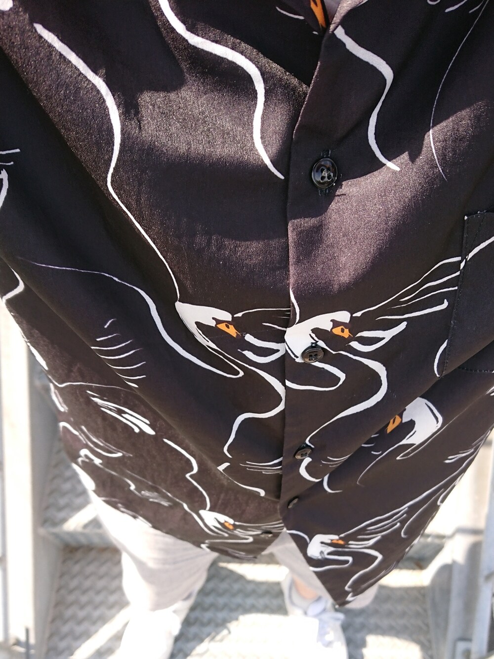 グレー系のパンツ、ブラック系のシャツ/ブラウス、ホワイト系のスニーカーを着用したメンズの春コーディネートの2枚目の写真