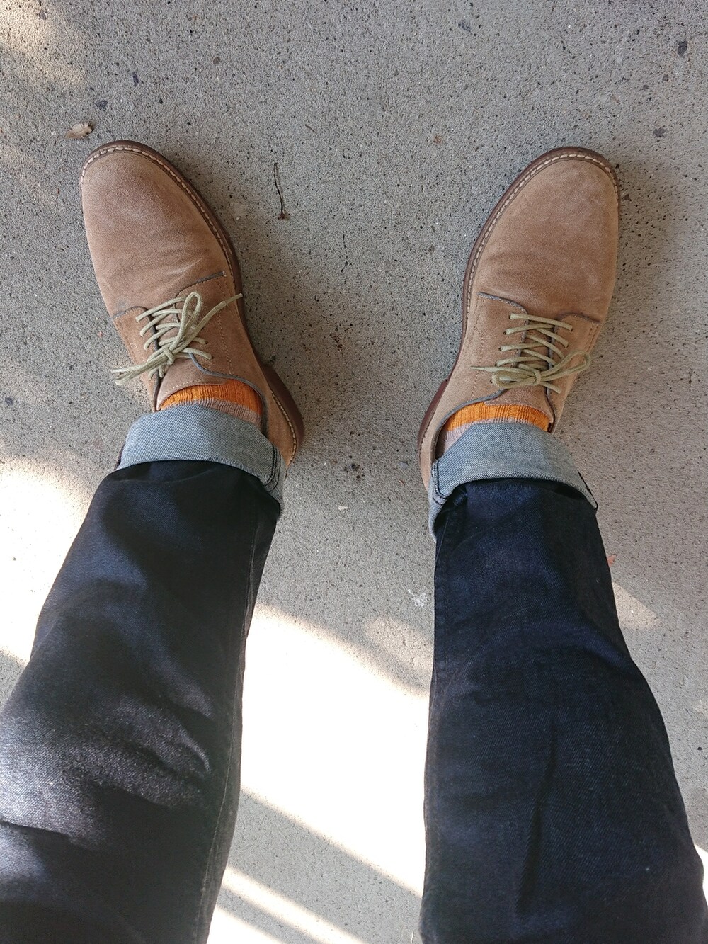 ブルー系のデニムパンツ、ベージュ系のシューズ、グリーン系のマウンテンパーカーを着用したメンズの秋コーディネートの2枚目の写真