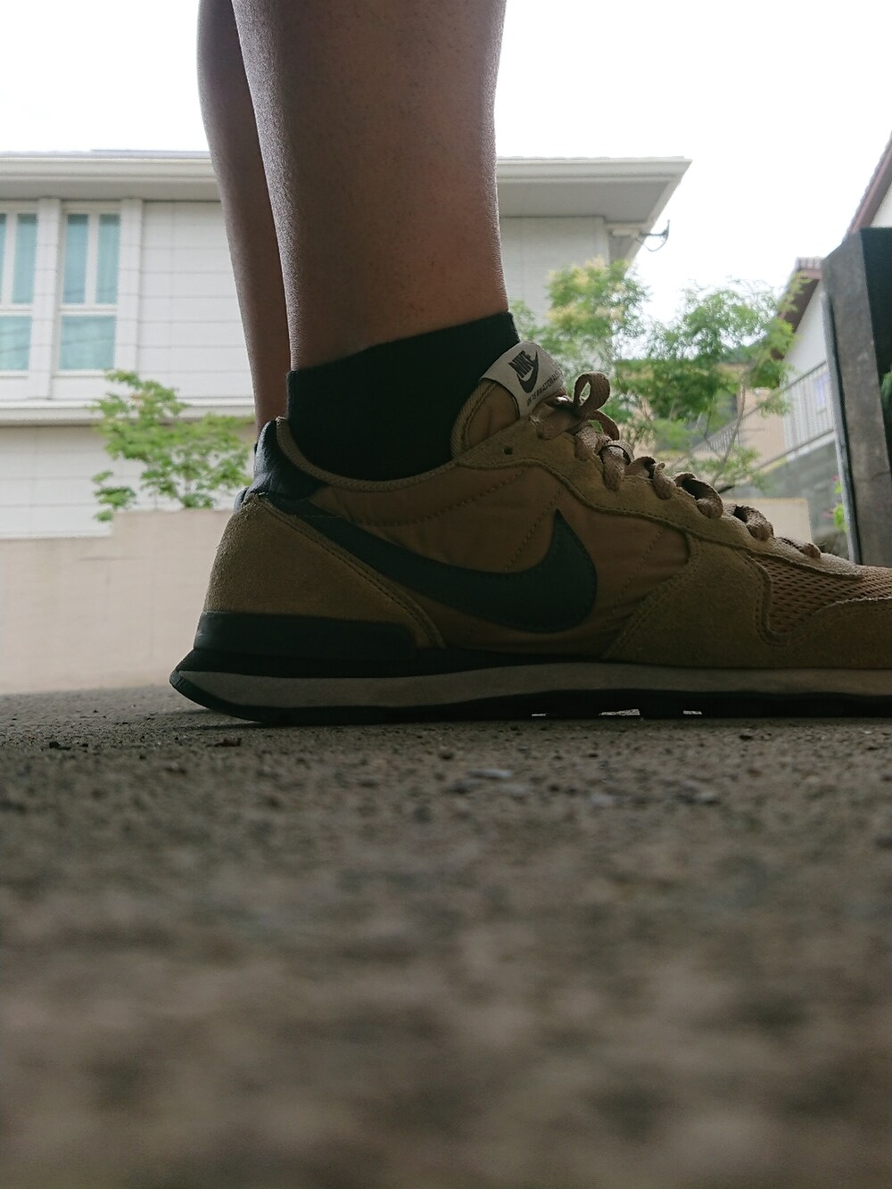 ブラック系のパンツ、ホワイト系のTシャツ/カットソー、ベージュ系のスニーカーを着用したメンズの夏コーディネートの2枚目の写真