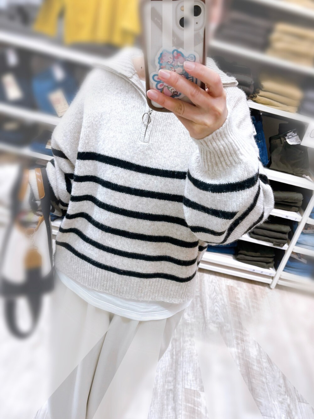 ベージュ系のニット/セーター、ホワイト系のパンツ、ホワイト系のトートバッグを着用したレディースの冬コーディネートの2枚目の写真