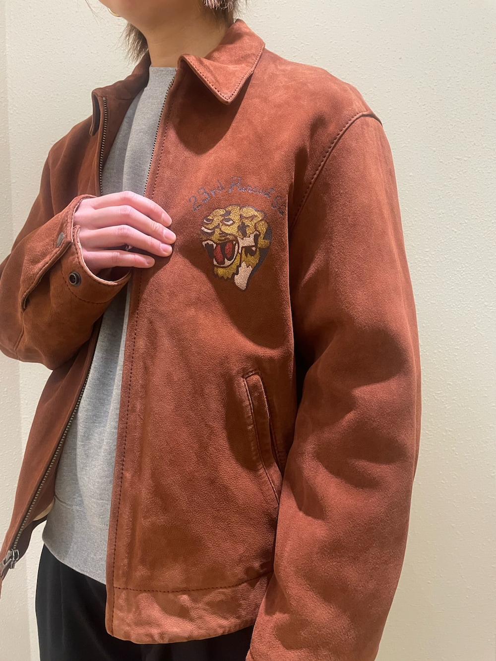 グレー系のスウェット、レッド系のライダースジャケット、ブラック系のキャップを着用したレディースの冬コーディネートの4枚目の写真