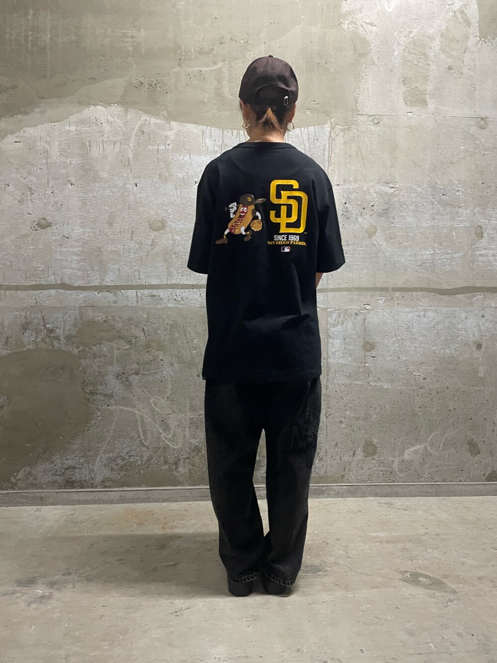 ブラック系のTシャツ/カットソー、ブラック系のショルダーバッグ、ブラック系のデニムパンツを着用したレディースの夏コーディネートの2枚目の写真