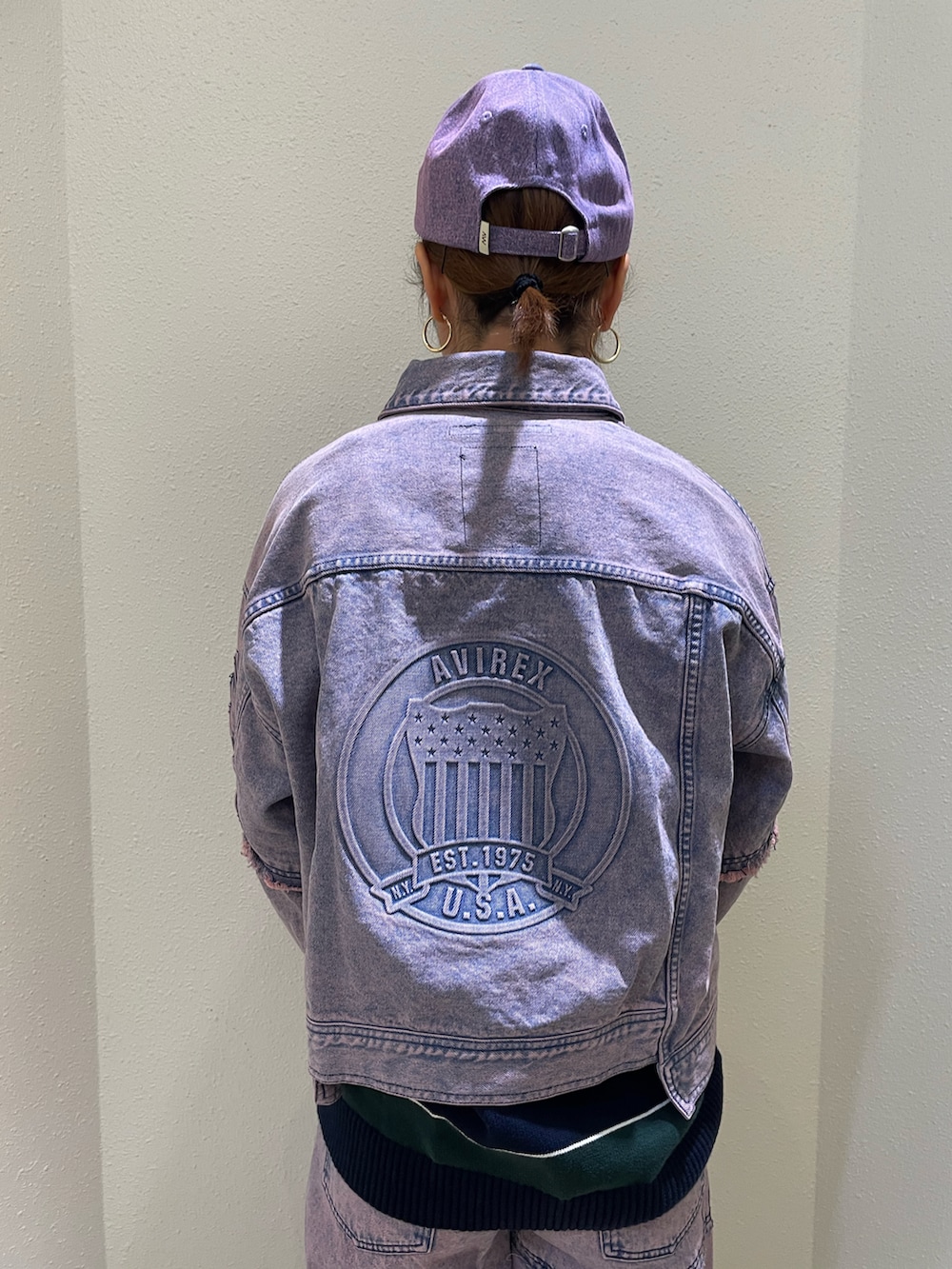 ピンク系のデニムジャケット、ピンク系のデニムパンツ、パープル系のショルダーバッグを着用したレディースの冬コーディネートの3枚目の写真